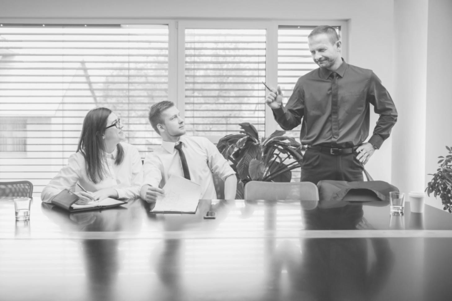 Early planning session with financial documents and laptops spread across a conference table